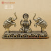 Decorative statue of a seated figure with two elephants on a beige background, featuring Dharma Statues branding.