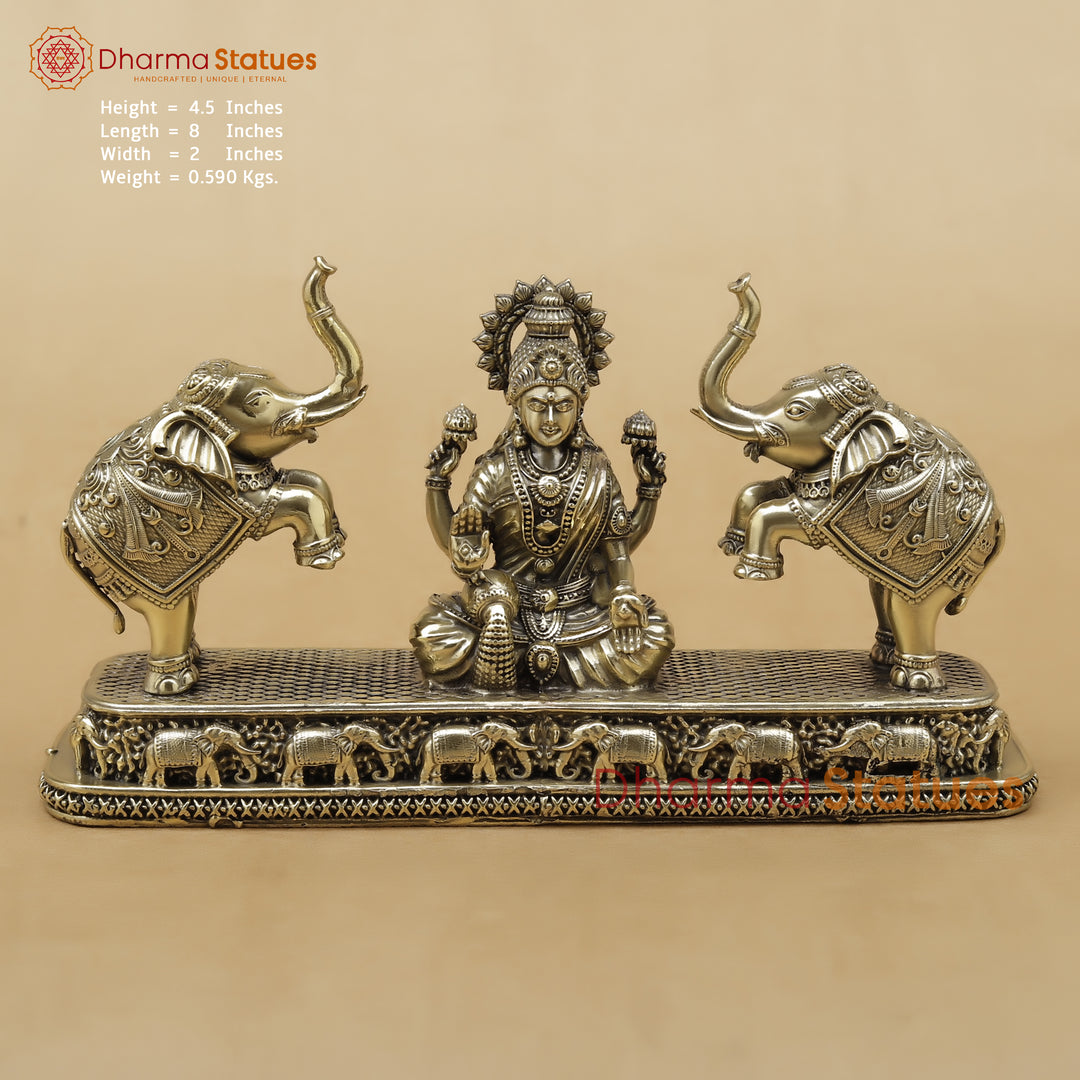 Decorative statue of a seated figure with two elephants on a beige background, featuring Dharma Statues branding.